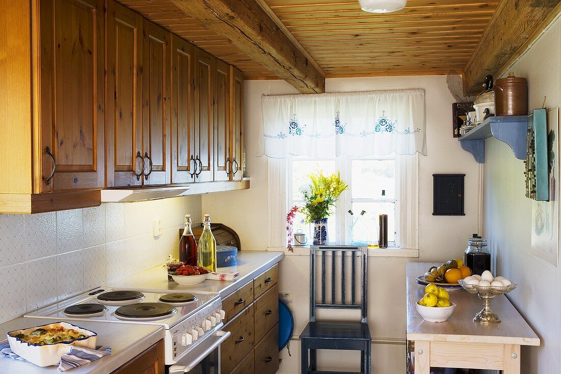 A kitchen in country house with wooden cupboard and a wooden ceiling