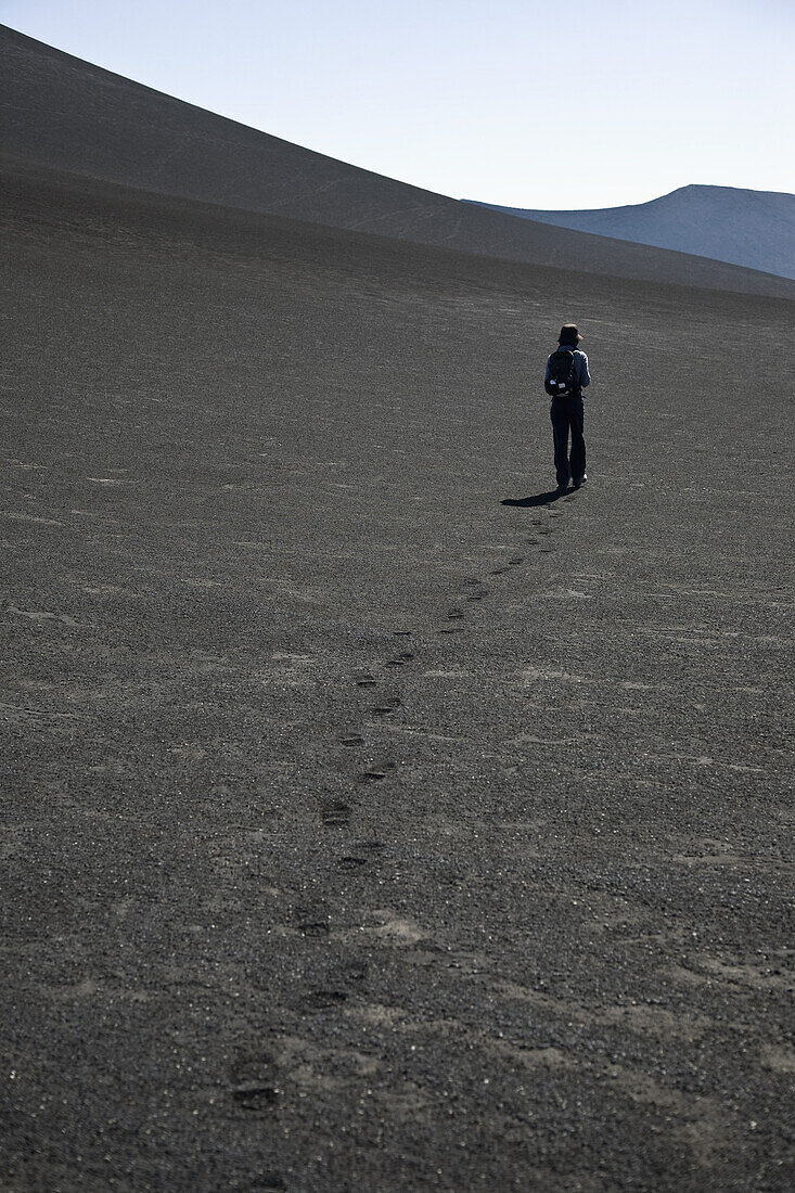 Rear view of a woman walking over Lonquimay Volcano, Patagonia, Chile