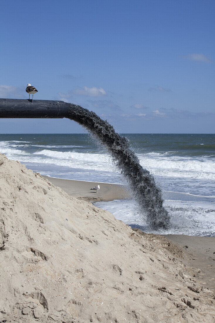 A large pipe pumping sand onto the beach