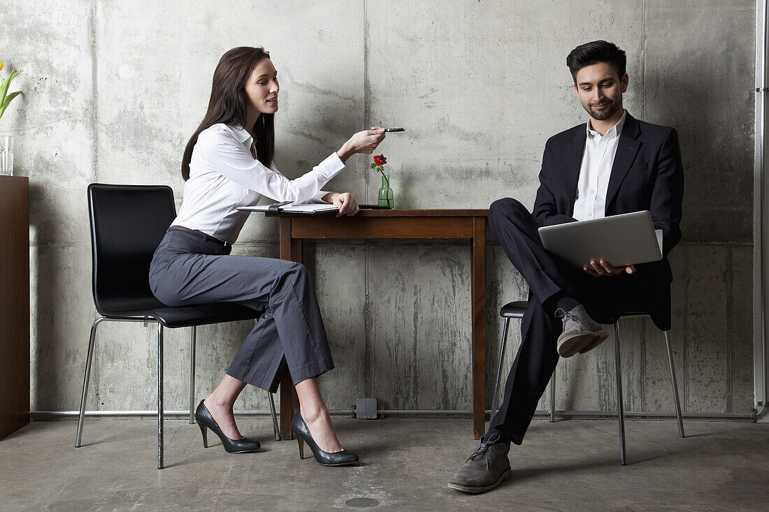 A businessman and businesswoman having a meeting in a modern office