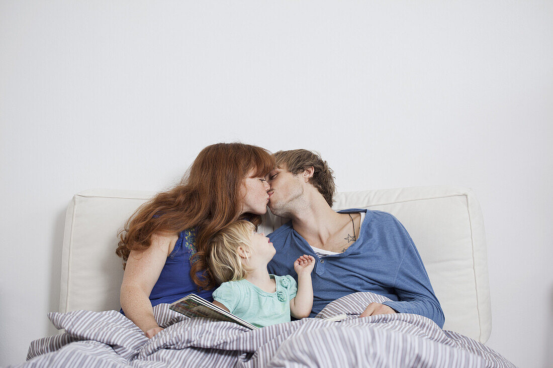 A young family in bed in the morning