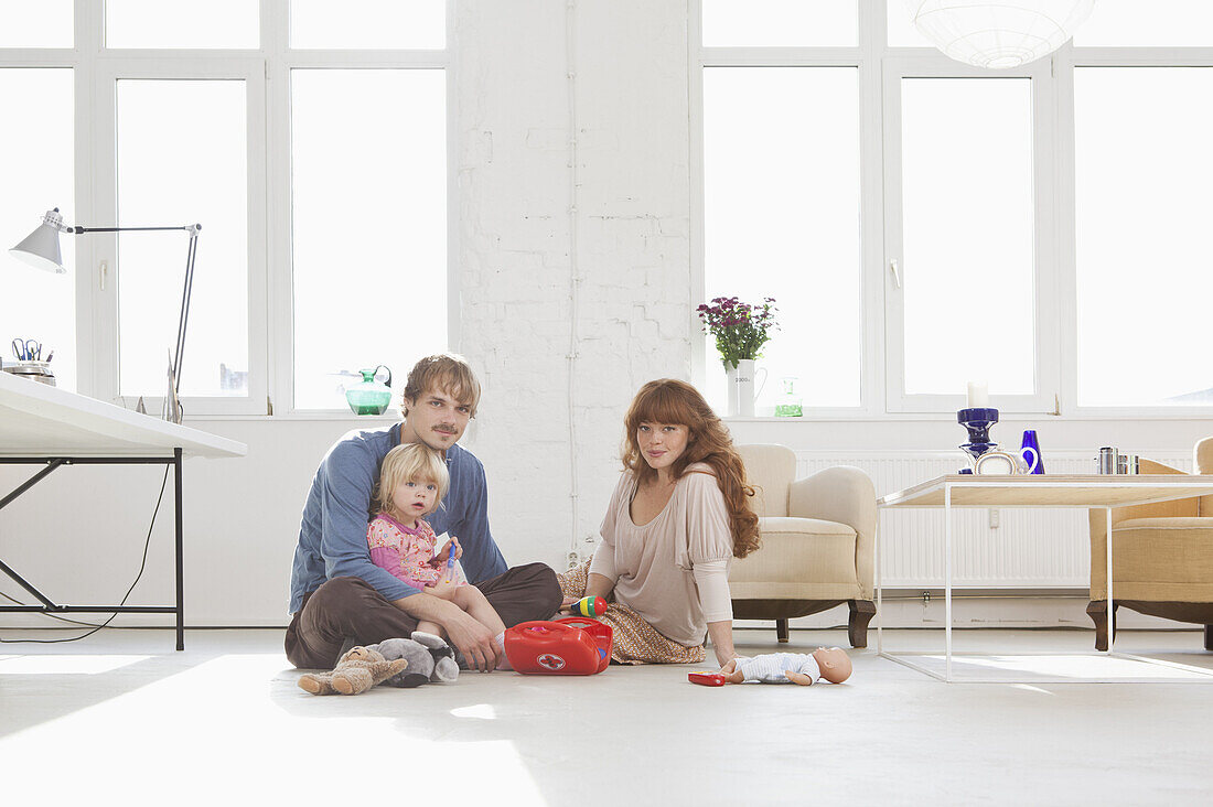 A young family playing with toys on the living room floor