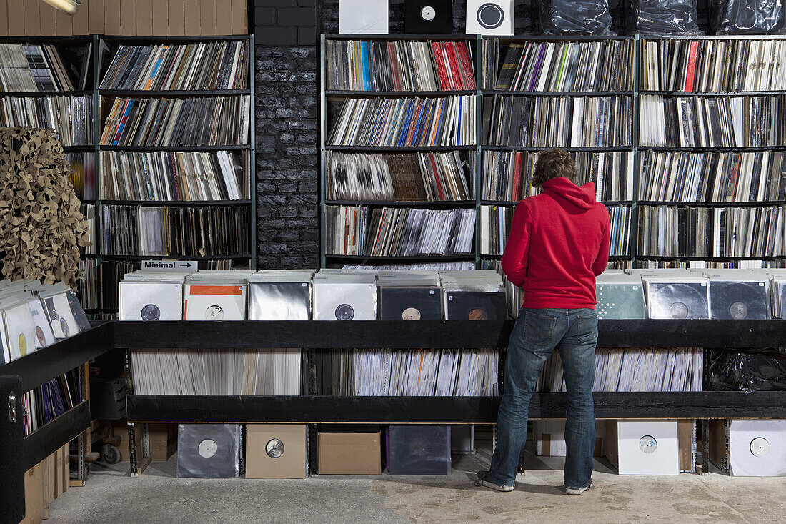Rear view of young man in a record store