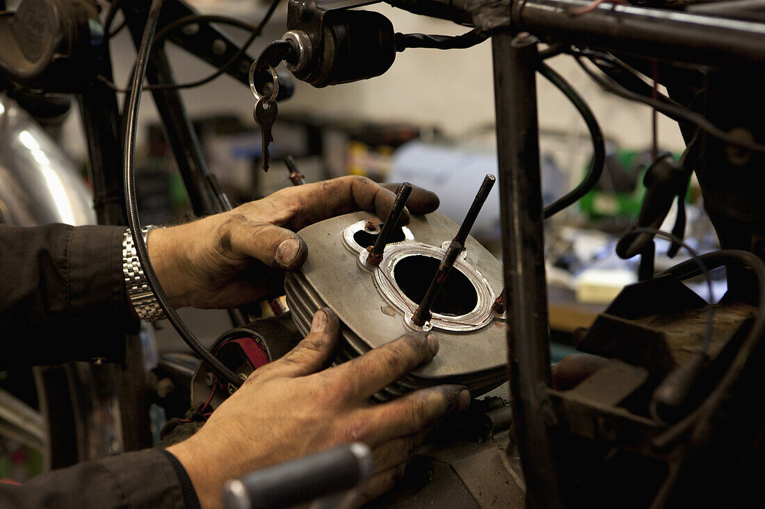 Mechanic attaching cylinder to motorcycle