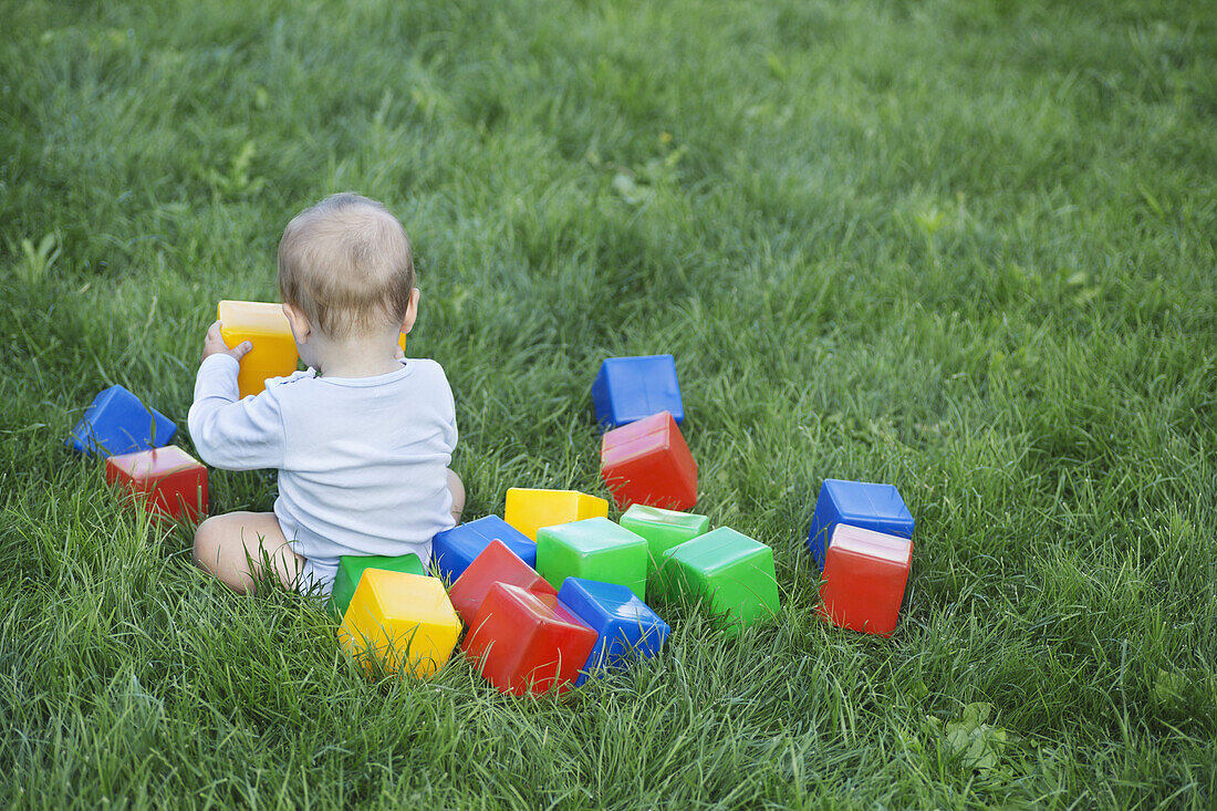 Baby in the garden with building blocks