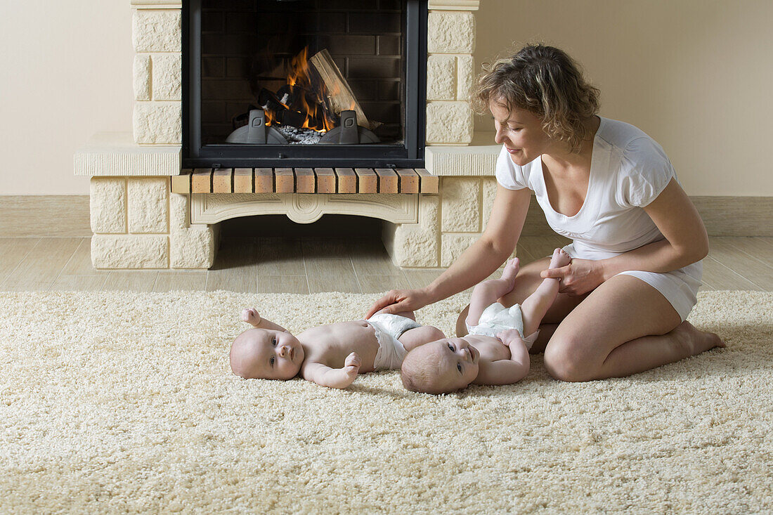 Mother and daughters on carpet in front of fire