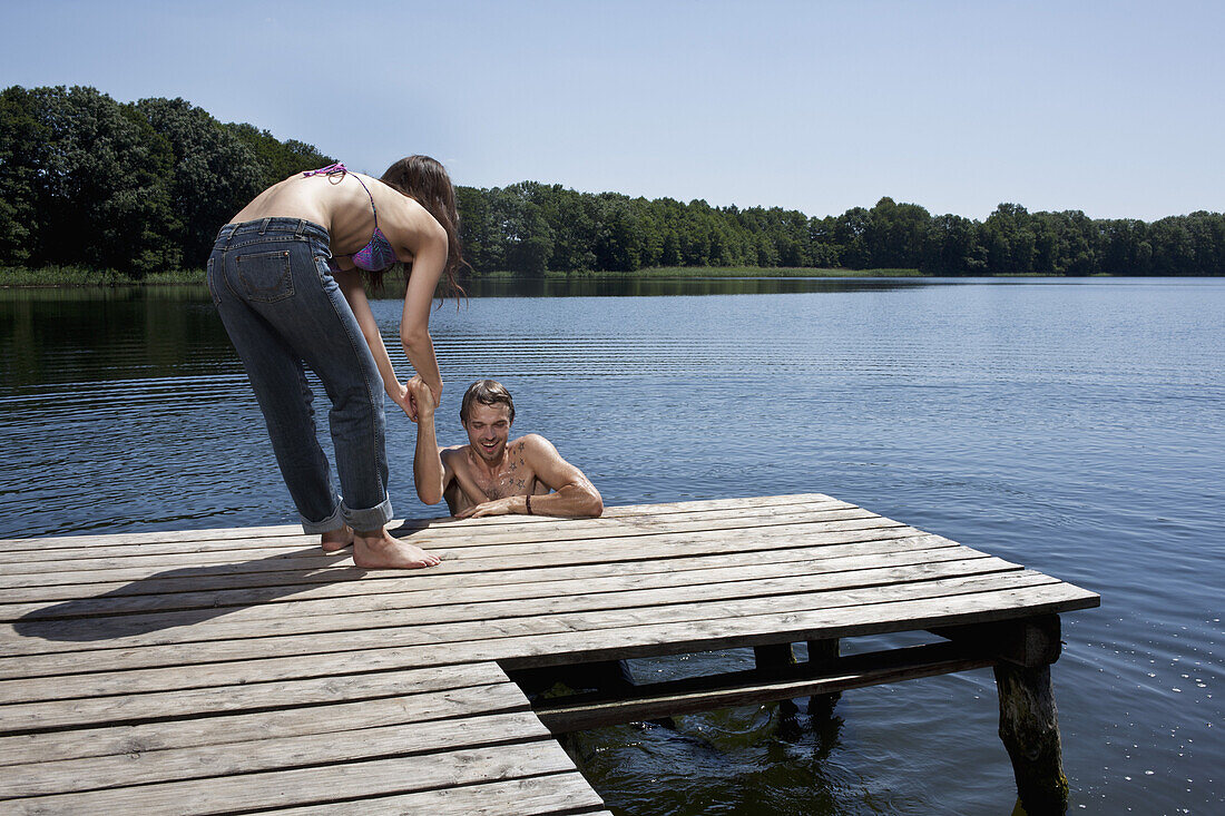Fun as woman helps man out of the water on jetty
