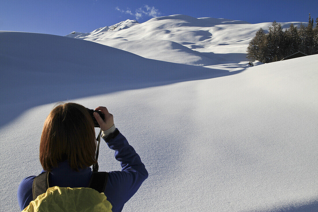 Tourist takes photos of snowy landscape