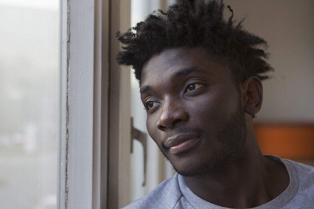 A young man looking out a window