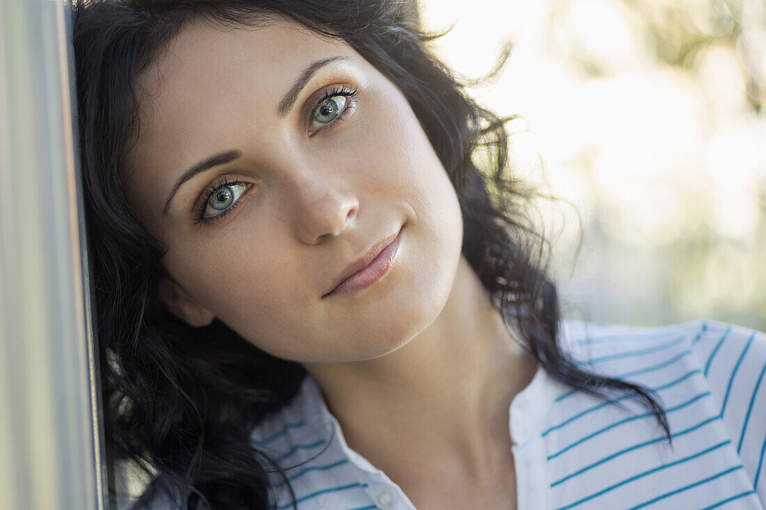 A beautiful young woman leaning against a wall