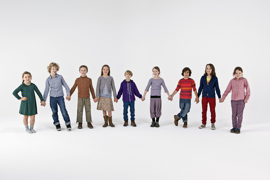 A group of kids standing in a row and holding hands