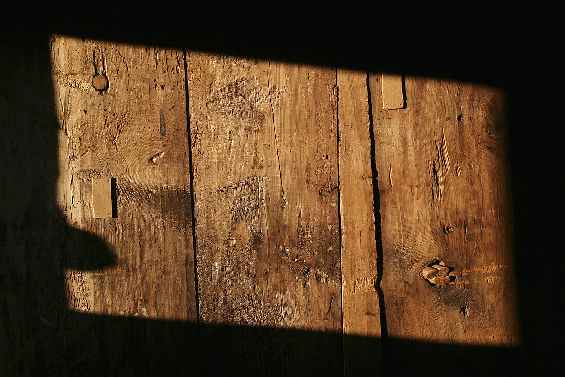 A rectangle shape of sunlight on a wooden structure, close-up