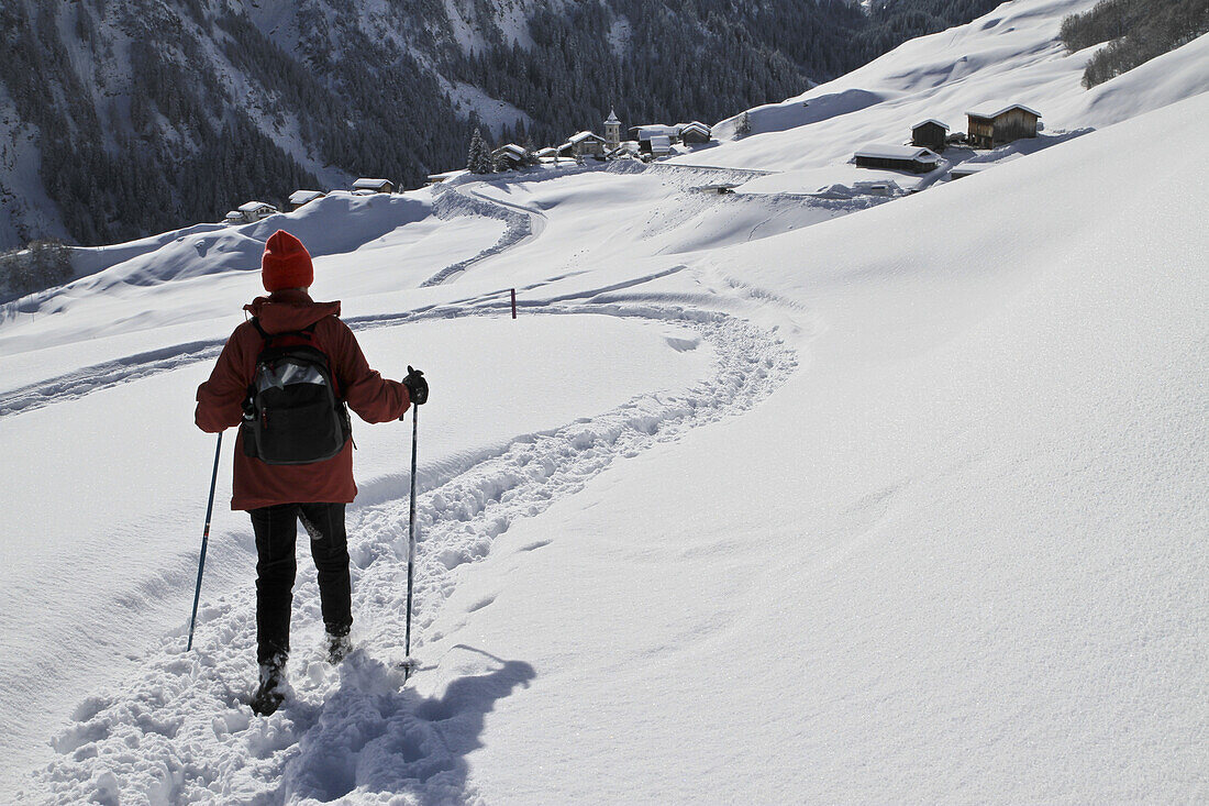 Hiker on the way to snowy village