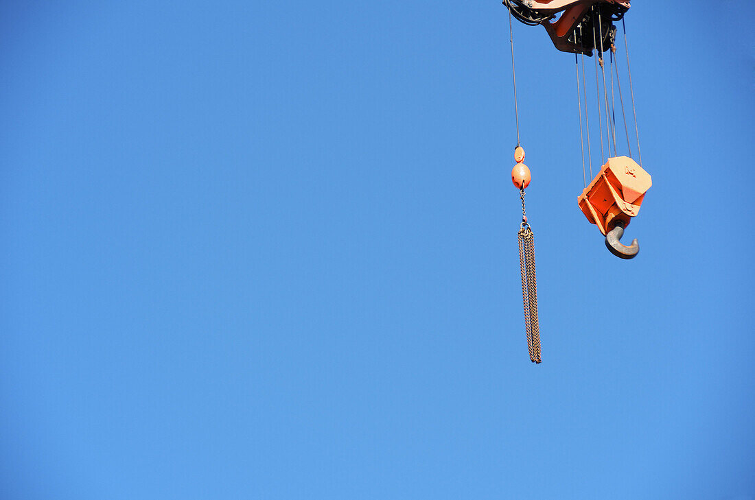 Crane hook against a clear blue sky
