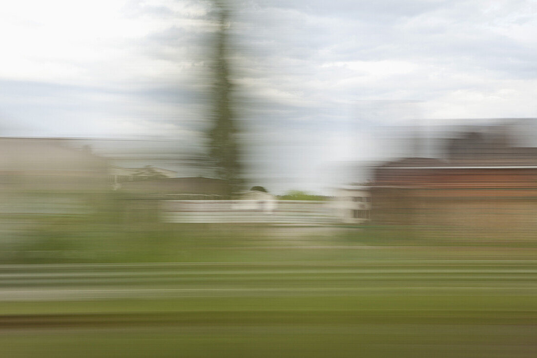 A village in blurred motion viewed from a moving train