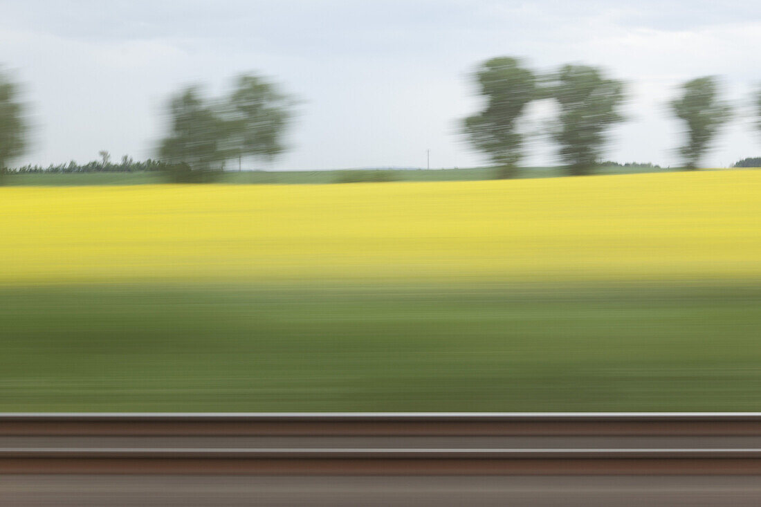 A rural landscape in blurred motion viewed from a moving train