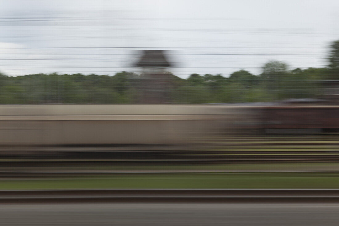 A village in blurred motion viewed from a moving train