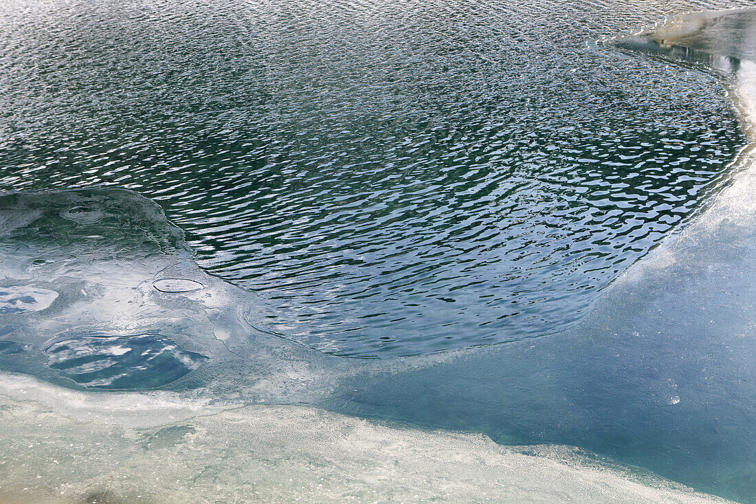 A lake with melting ice on top