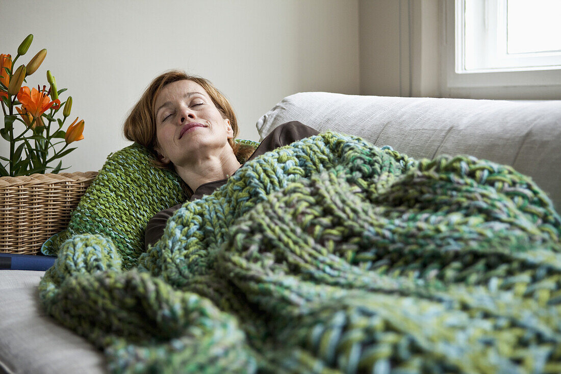 A woman napping on a sofa