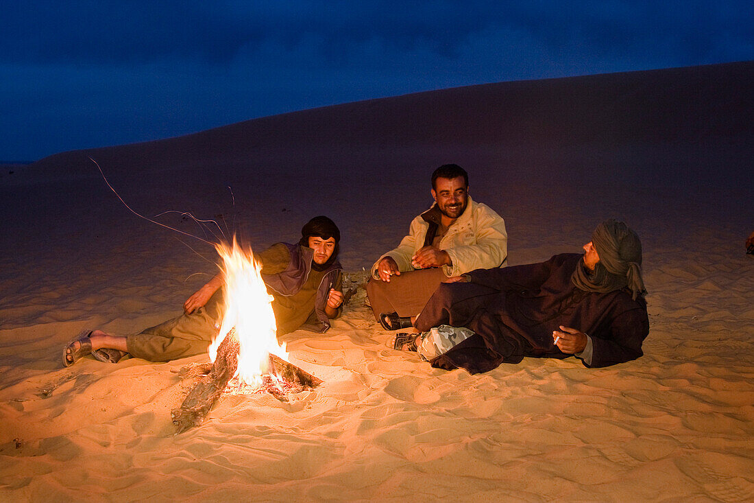 beduins warming at campfire, Akakus mountains, Libya, Africa