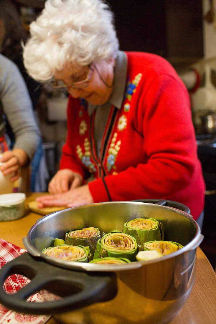 Kochen in der Toskana, hausgemacht, Mamma bei Vorbereitung von Artischocken in Topf, Toskana, Italy