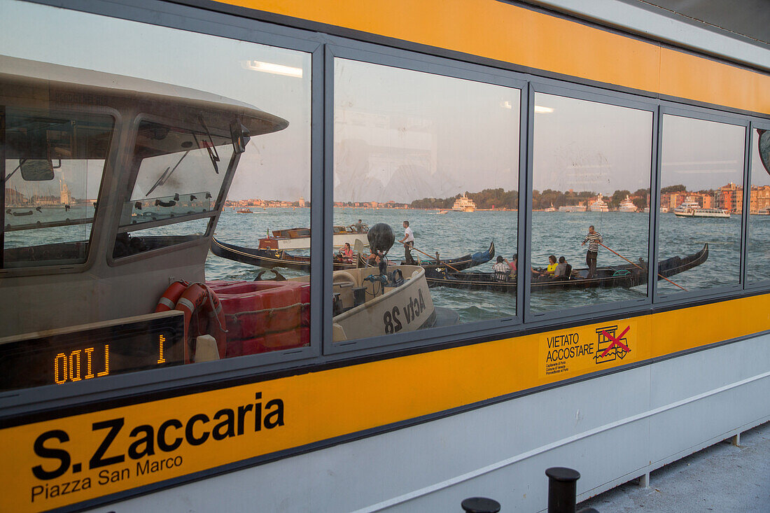 Vaporetto waterbus, floating jetty, mooring, pontoon,  approdo, reflection of water and gondola, Venice, Italy