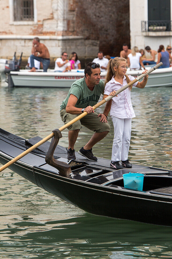 father teaches daughter standup rowing in venetian gondola, Canal Grande, Veneto, Venice, Italy