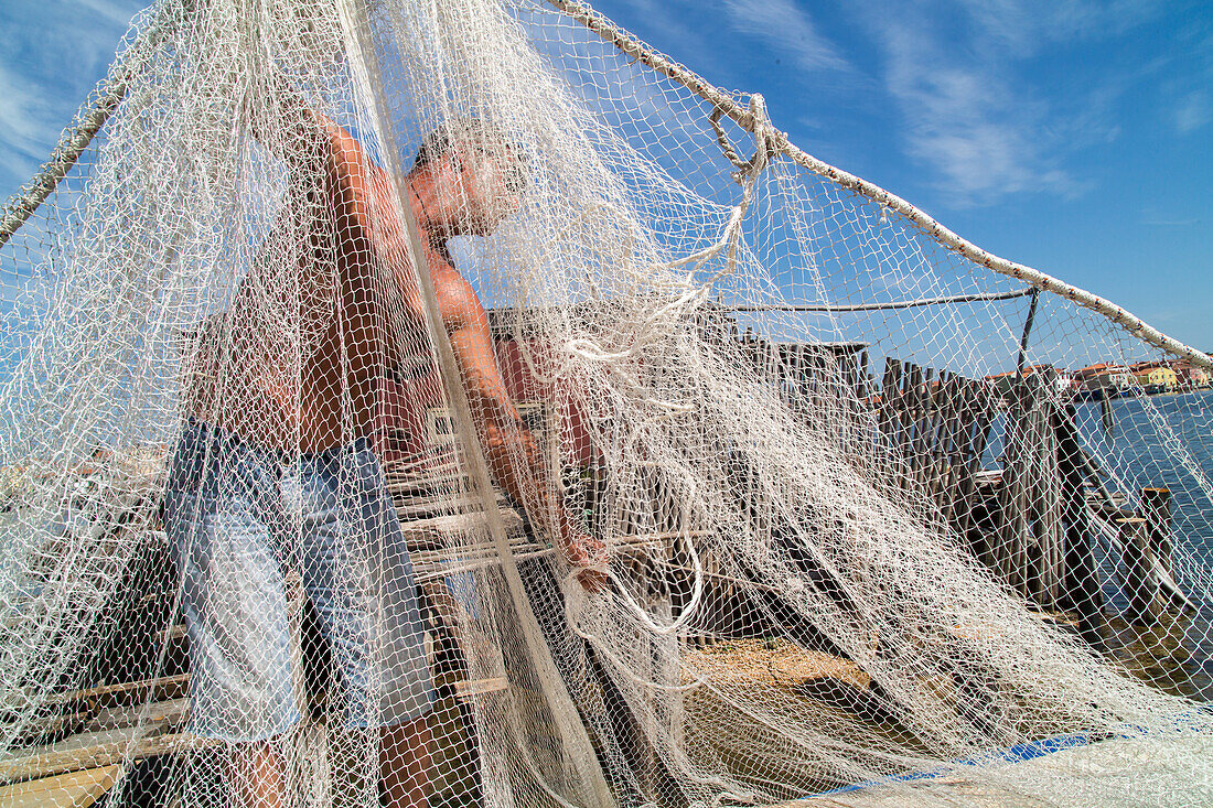 Fishermen with bilanciono nets on a traditional casone, shelter on stilts, Pellestrina, Island, lagoon, Venice, Italy