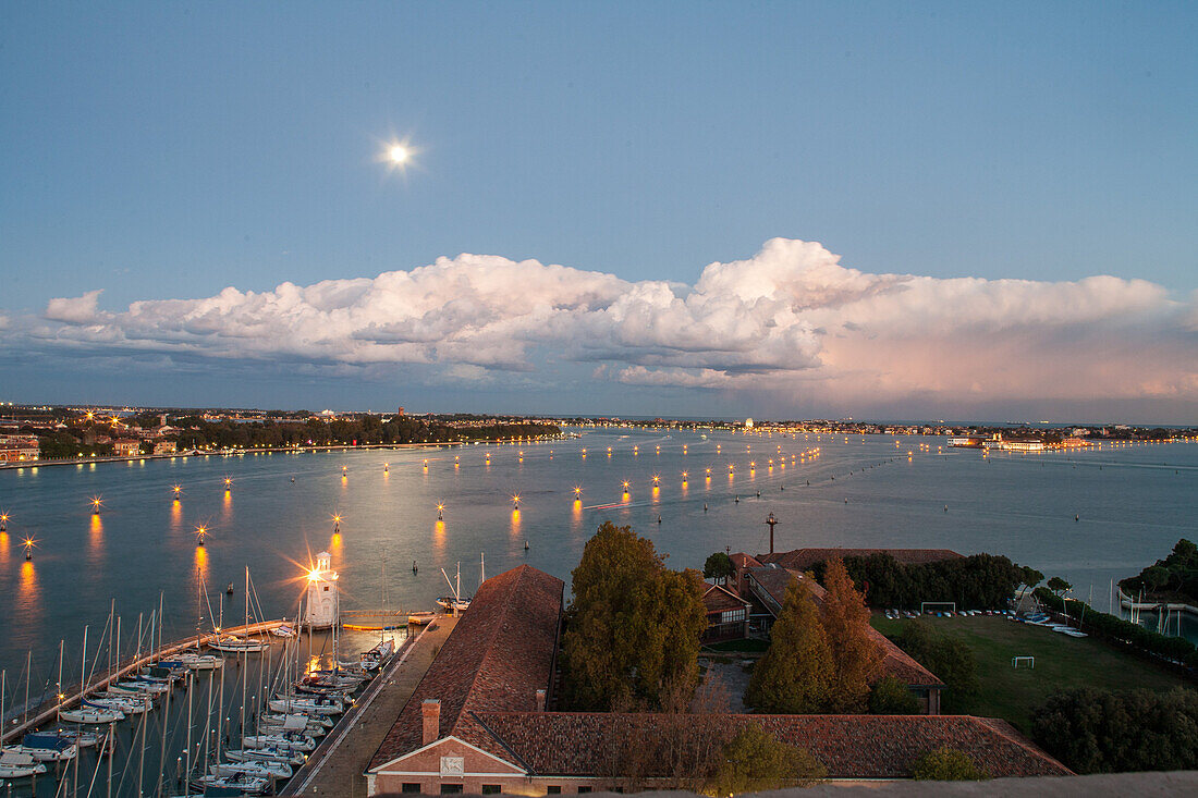 evening view, clouds, moon, from campanile of church San Giorgio Maggiore, island, Venice yacht club, Canale di San Marco, lit harbour entrance, Venice, Italy