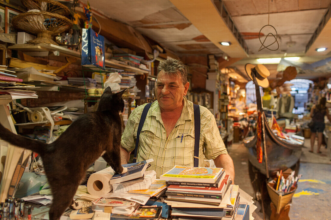 Luigi Frizzo, bookshop  Libreria Acqua Alta, piles of books, cat, gondola, Venice, Italy