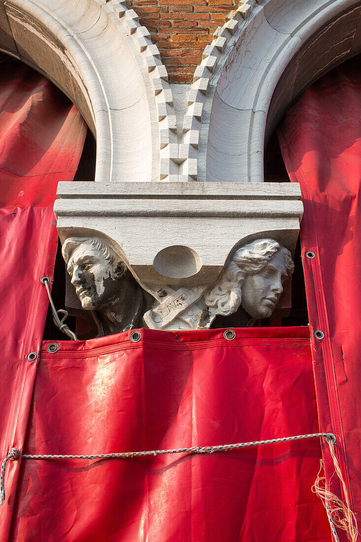 Pescheria Nuova, detail, capital, head of column, red tarpaulin of Rialto fish market, white pillar, Venice, Italy