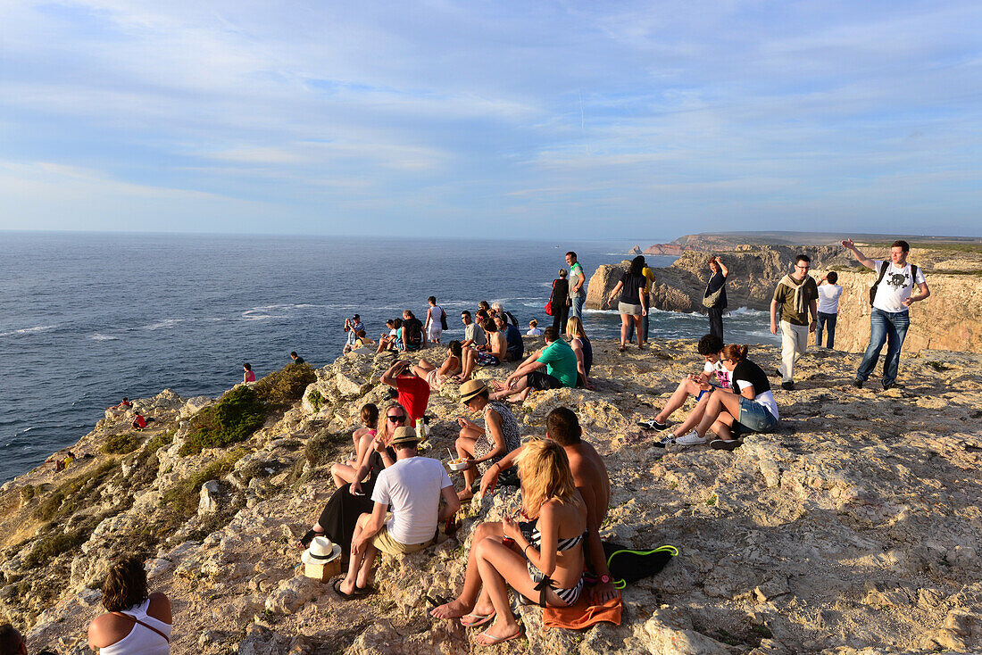 Leute betrachten den Sonnenuntergang am Cabo Sao Vicente bei Sagres, Algarve, Portugal