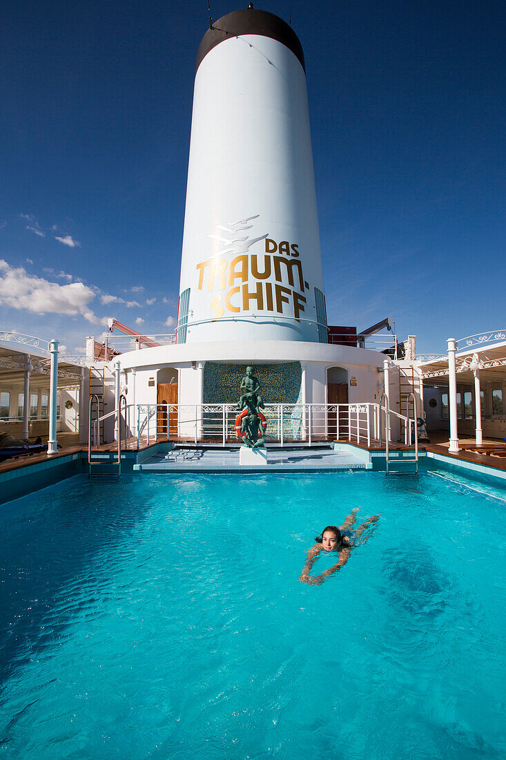 Junge Frau schwimmt in Pool von Kreuzfahrtschiff MS Deutschland (Reederei Peter Deilmann), nahe Sevilla, Andalusien, Spanien, Europa