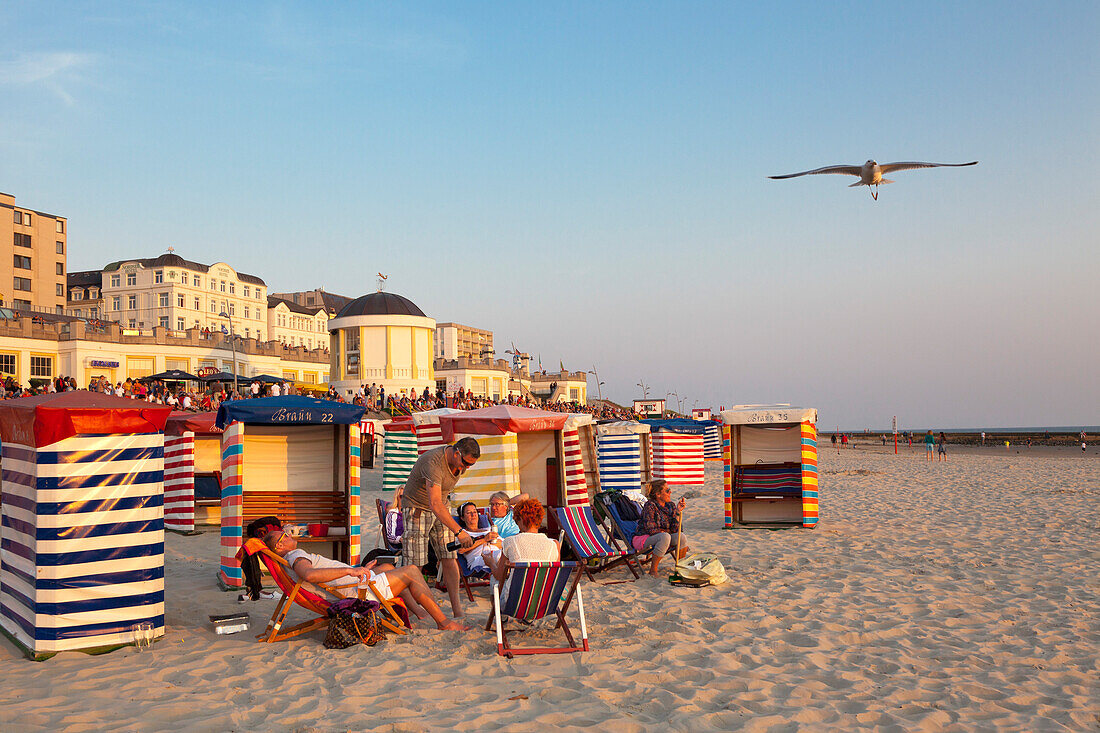 Menschen am Strand, Strandpromenade und Pavillon im Hintergrund, Insel Borkum, Ostfriesland, Niedersachsen, Deutschland