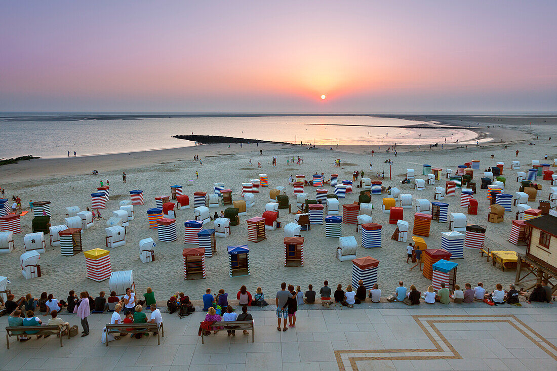 Menschen auf der Strandpromenade betrachten den Sonnenuntergang, Insel Borkum, Ostfriesland, Niedersachsen, Deutschland