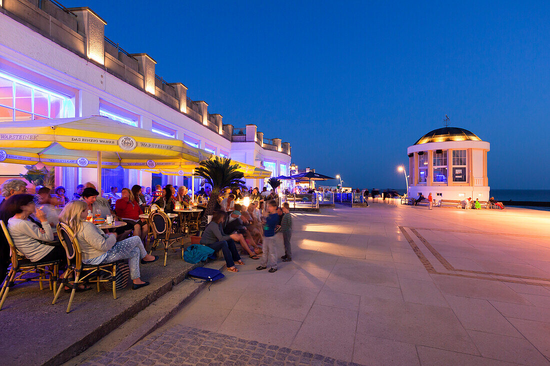 Menschen im Café an der Strandpromenade, Pavillon im Hintergrund, Insel Borkum, Ostfriesland, Niedersachsen, Deutschland