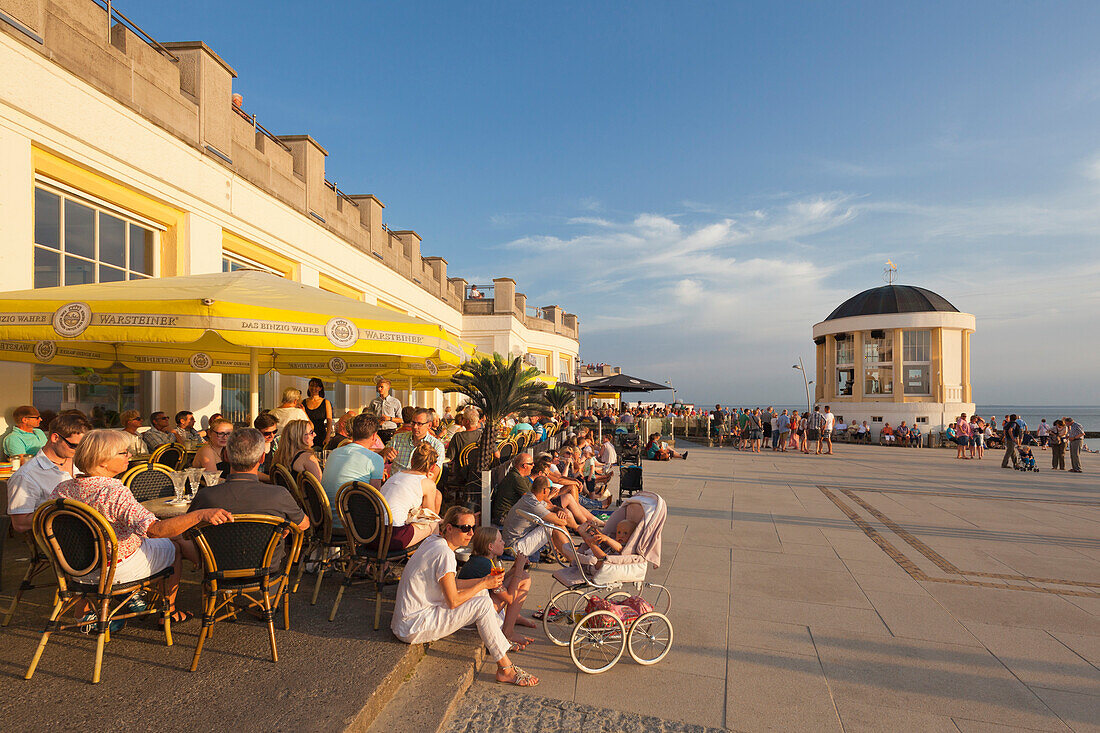 Menschen im Café an der Strandpromenade, Pavillon im Hintergrund, Insel Borkum, Ostfriesland, Niedersachsen, Deutschland