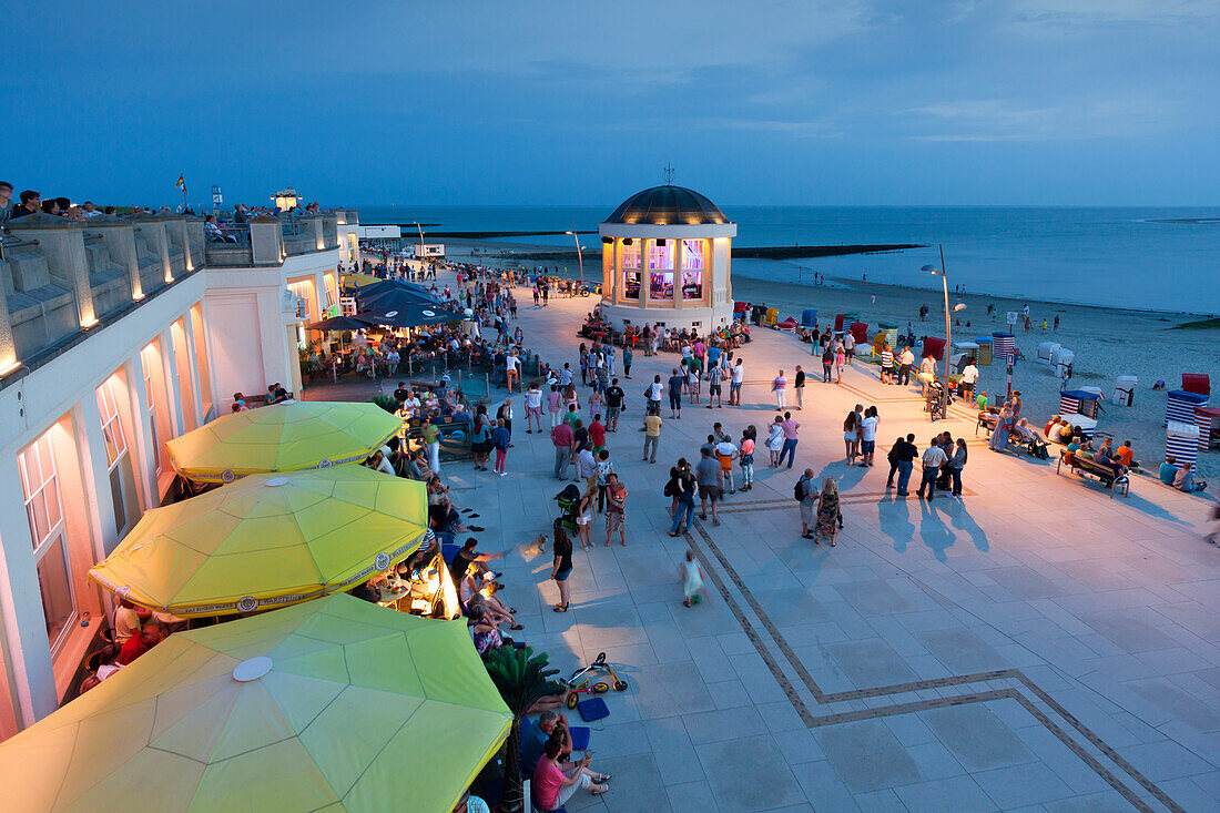 Menschen im Café an der Strandpromenade, Pavillon im Hintergrund, Insel Borkum, Ostfriesland, Niedersachsen, Deutschland