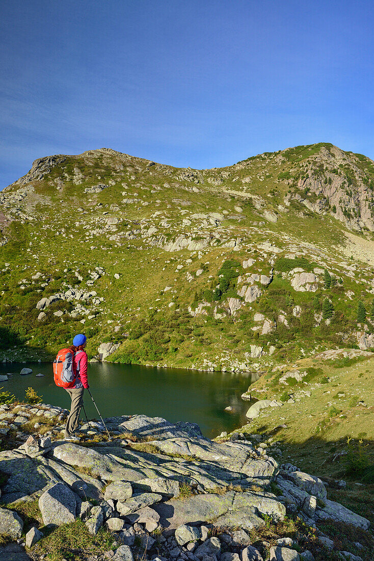 Frau beim Wandern blickt auf Bergsee Lago delle Trote, Lago delle Trote, Trans-Lagorai, Lagorai-Höhenweg, Lagorai, Dolomiten, UNESCO Welterbe Dolomiten, Trentino, Italien