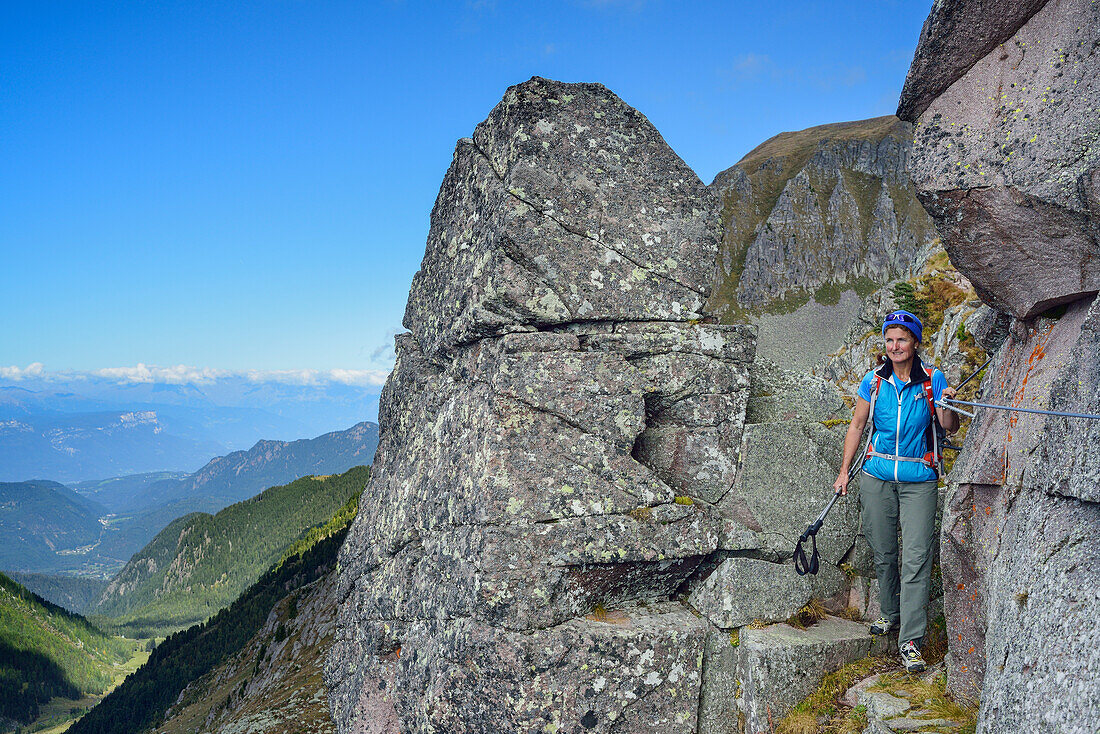 Woman hiking on fixed rope route between boulders, Trans-Lagorai, Lagorai range, Dolomites, UNESCO World Heritage Site Dolomites, Trentino, Italy