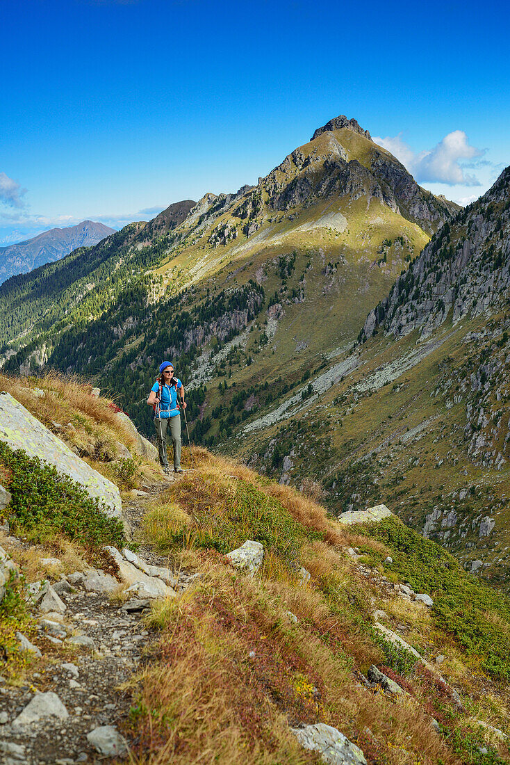 Woman hiking with mountains in the background, Trans-Lagorai, Lagorai range, Dolomites, UNESCO World Heritage Site Dolomites, Trentino, Italy