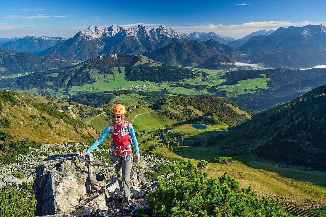 Frau steigt über Klettersteig auf, Loferer Steinberge im Hintergrund, Klettersteig Henne, Henne, Kitzbüheler Alpen, Tirol, Österreich