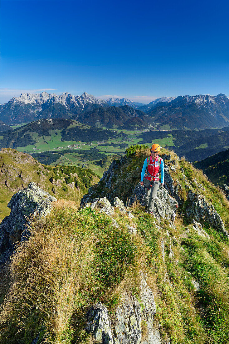 Woman ascending ridge, Loferer Steinberge range in background, Henne, Kitzbuehel range, Tyrol, Austria