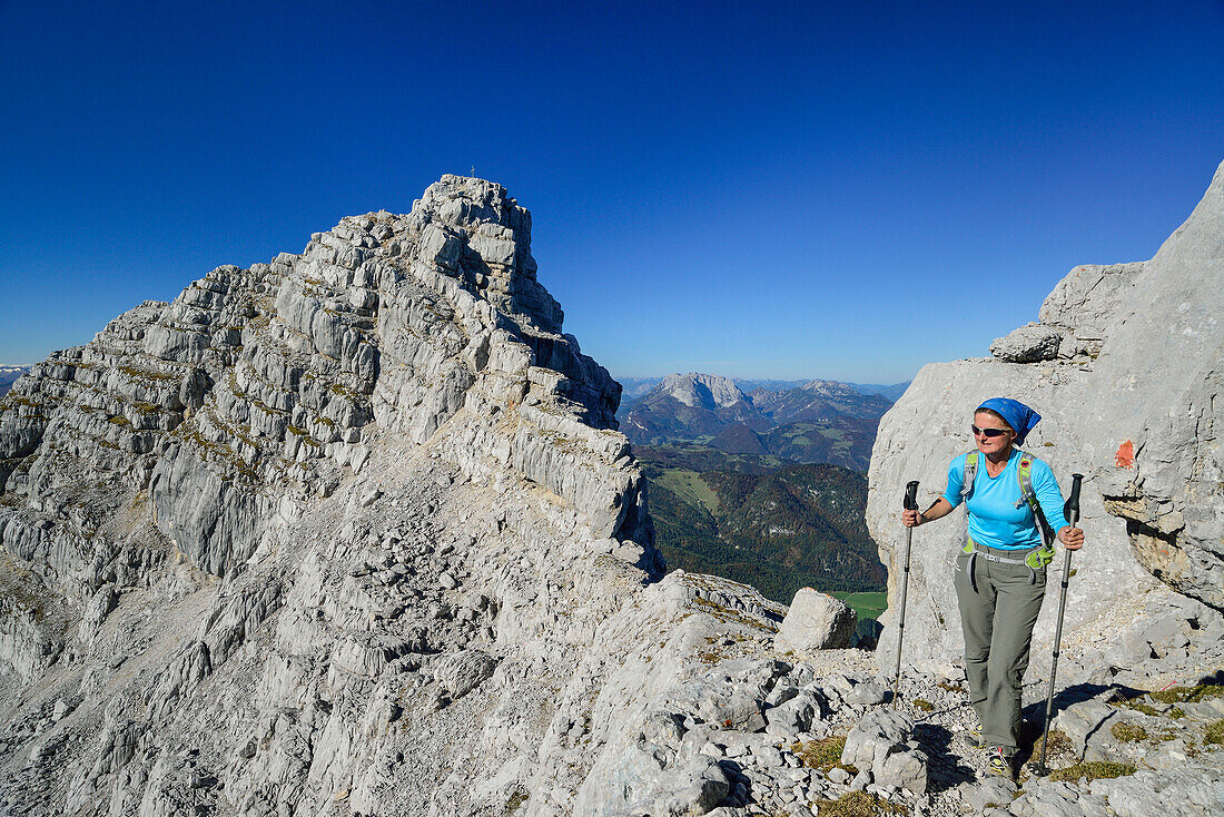 Frau wandert auf Felsgrat mit Blick auf Rothörnl und Kaisergebirge, Nurracher Höhenweg, Loferer Steinberge, Tirol, Österreich