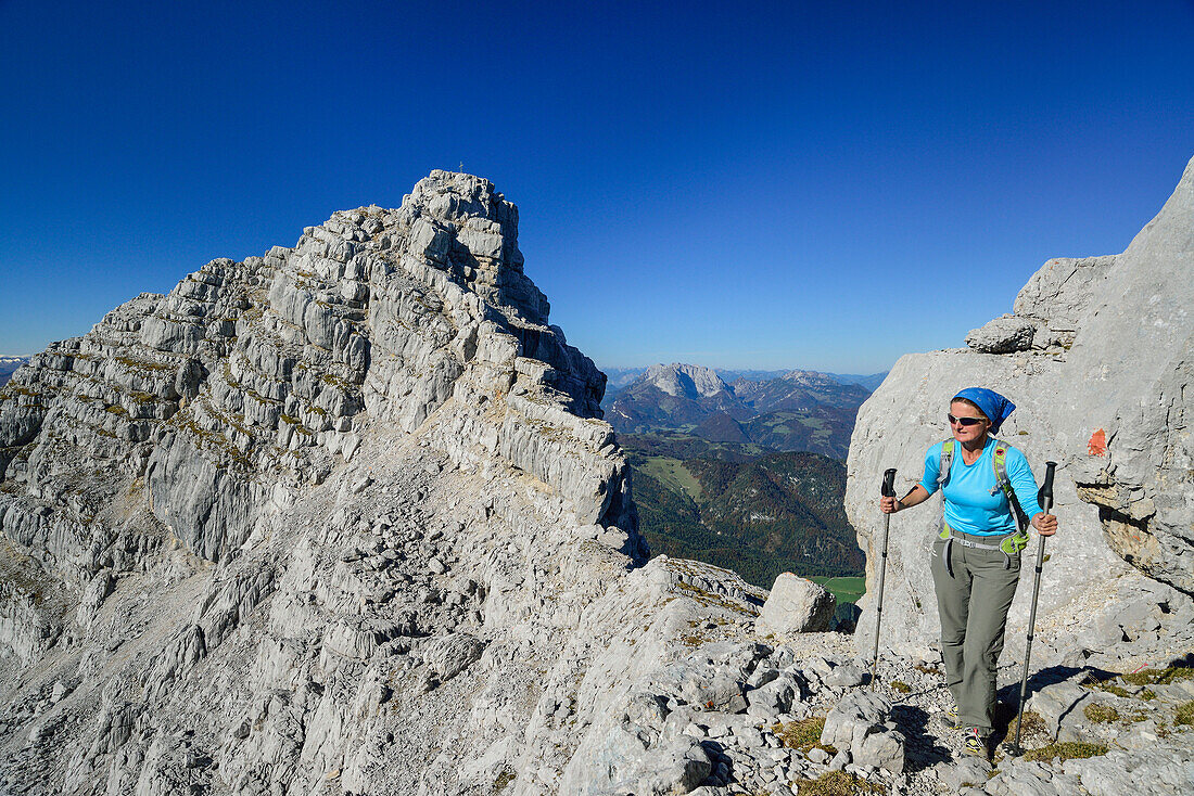Woman hiking on rocky ridge with view to Rothoernl and Kaiser range, Nurracher Hoehenweg, Loferer Steinberge range, Tyrol, Austria