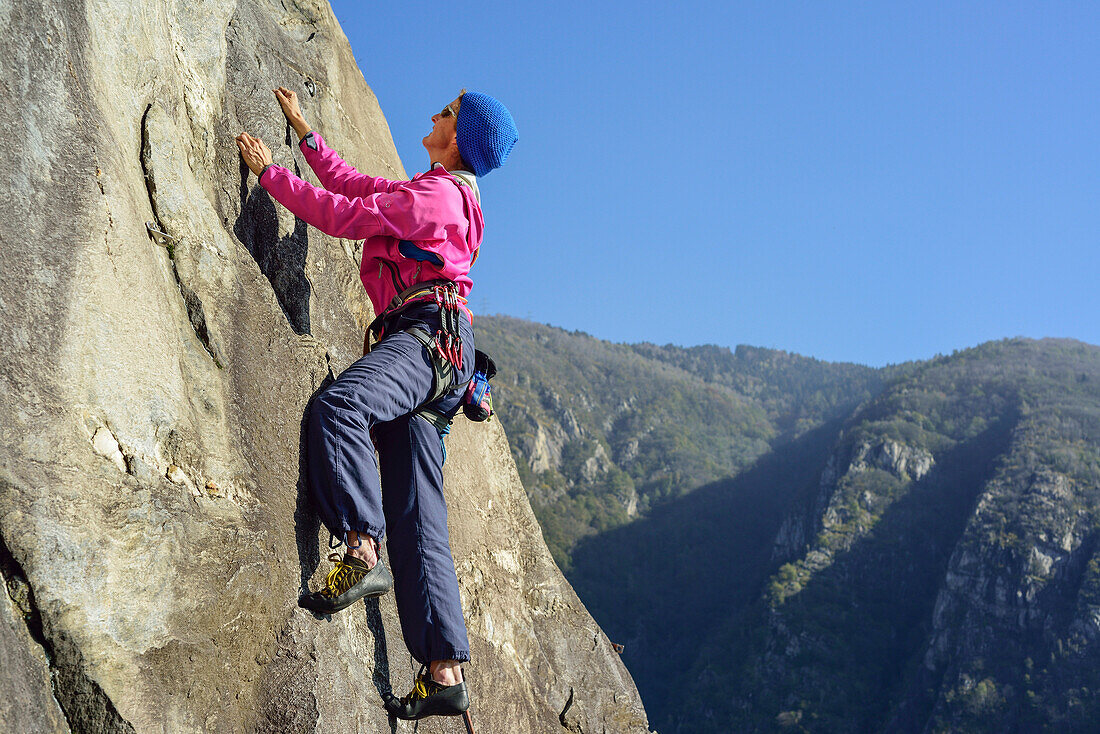 Frau klettert über Gneisfelsen, Placca di Tegna, Ponte Brolla, Tessin, Schweiz