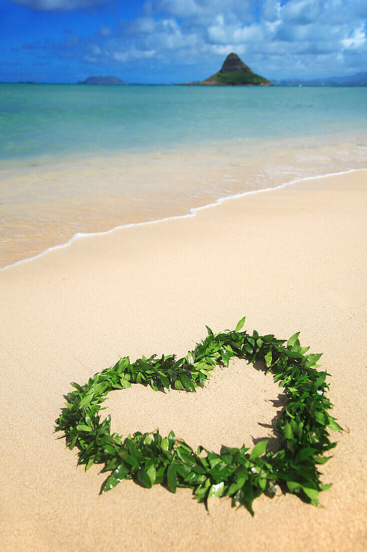 Hawaii, Oahu, Kualoa, Heart Shaped Maile Lei On The Beach With Chinamans Hat In Background