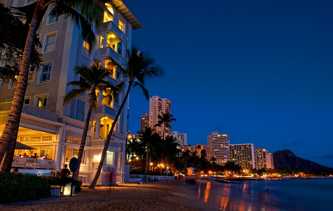 Hawaii, Oahu, Waikiki, Waikiki Beach At Night With Veiw Of City Lights And Diamond Head In Background.