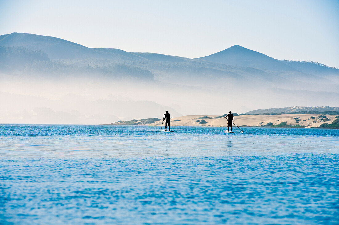 California, Morro Bay State Park, Two People Stand Up Paddleboard In Ocean.