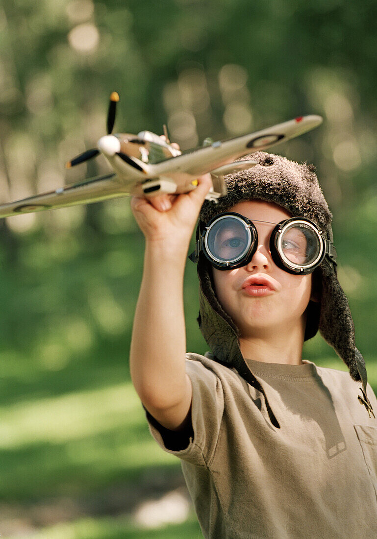 'Fv2070, Natural Moments Photography; Young Boy With Aviator Goggles And Hat Playing With A Toy Plane'